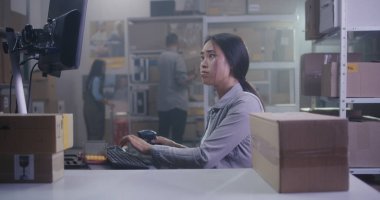 Kadın barkod tarayıcı ile paketleri kontrol ediyor