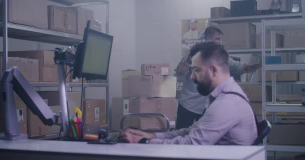 Trabalhadores no centro de distribuição encontrando fone de ouvido VR na caixa — Vídeo de Stock