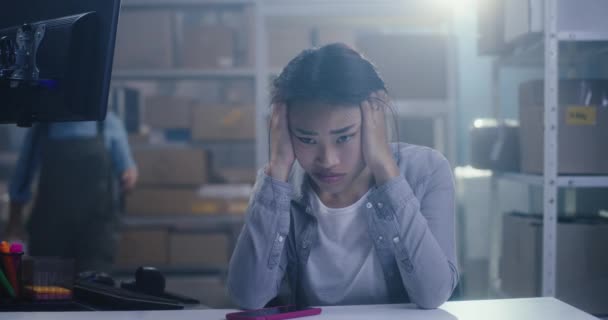 Jeune femme ennuyée travaillant dans un entrepôt