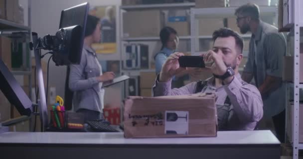 Arbetstagaren fotograferar skadad förpackning — Stockvideo