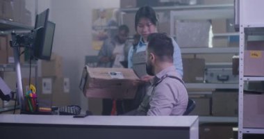 İşçiler hasarlı paketi kontrol ediyor