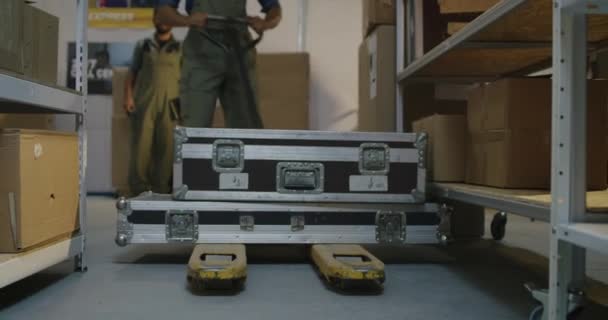 Worker placing road cases on shelves — Stock Video