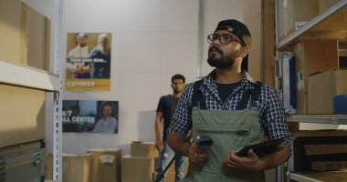 Depodaki paketleri kontrol eden işçiler