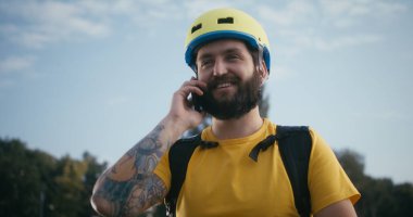 Bisikletli kurye telefonla konuşuyor.