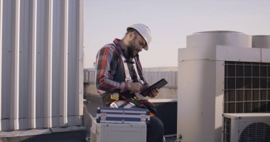 Telefonla konuşurken tablet kullanan bir mühendis.