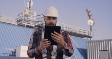 Mühendisler bir baz istasyonunda tablet kullanıyorlar.