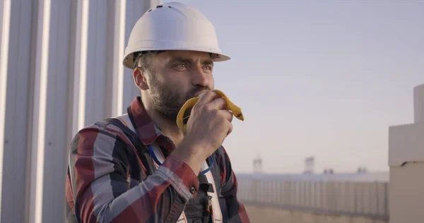 Ingeniero comiendo un plátano durante su descanso — Foto de Stock