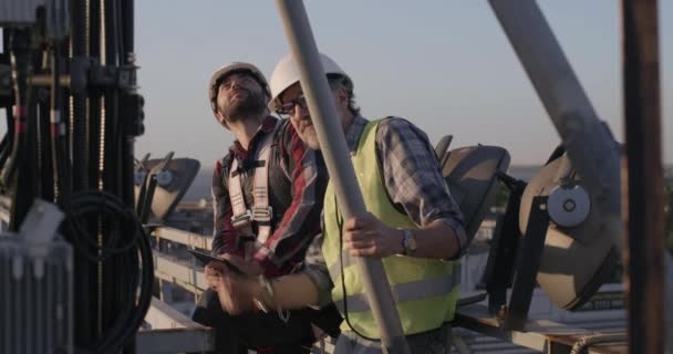 Ingenieros trabajando en una torre celular — Vídeos de Stock