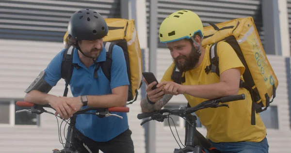 Messaggeri in bicicletta controllare smartphone — Foto Stock