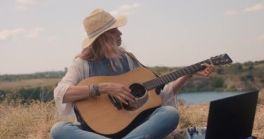 Çayırda gitar çalan kadın