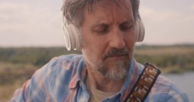 Adam çayırda müzik çalıyor