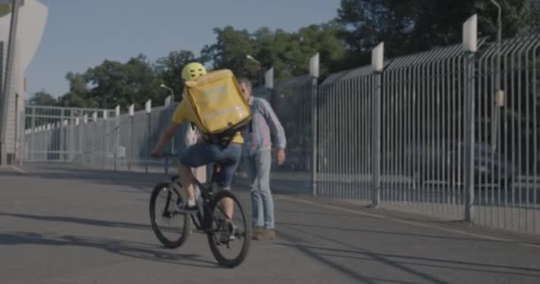 Велокурьер доставляет еду для пары — стоковое видео