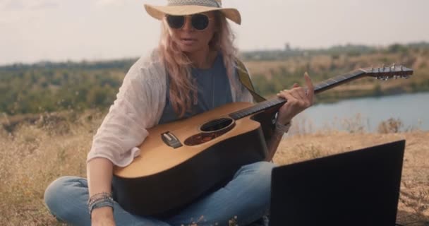 Guitariste féminine utilisant un ordinateur portable — Video