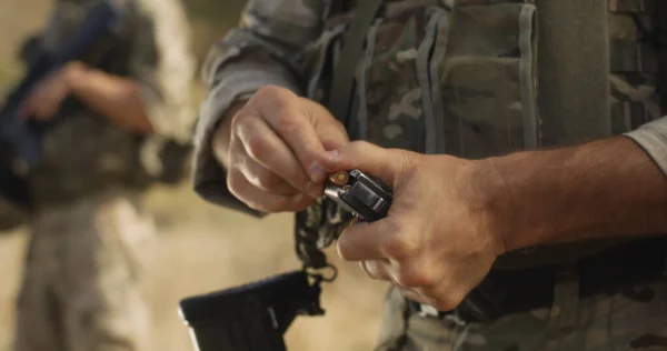 Żołnierz zbożowy przeładowuje broń podczas bitwy — Zdjęcie stockowe