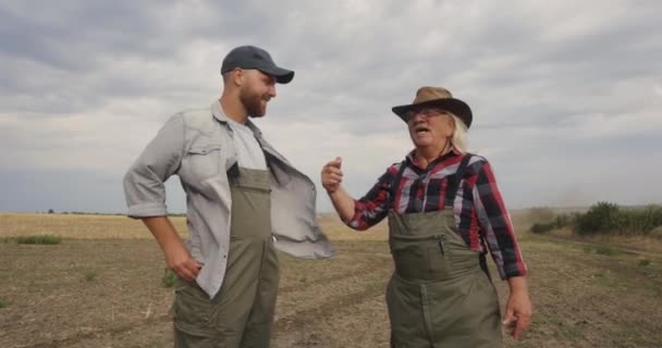 Фермери розмовляють під час плуга в полі — стокове відео