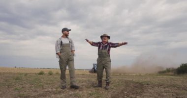 Mutlu kıdemli çiftçiler torunlarına tarlayı gösteriyor.