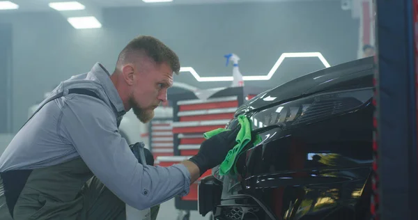 Técnico masculino que lava el faro del coche — Foto de Stock