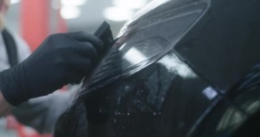 Ekin teknisyeni farlara film uyguluyor