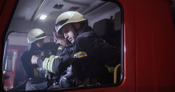 Equipa de bombeiros a entrar no camião — Fotografia de Stock