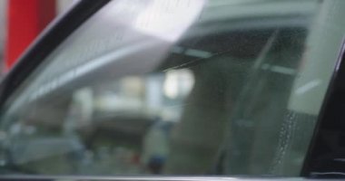 Kırpılmış mekanik araç penceresinde film kesiyor