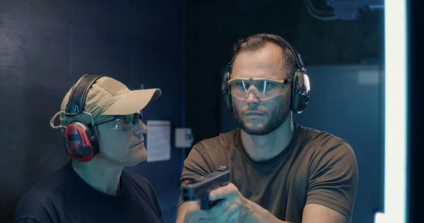 Mature instructor teaching man to shoot pistol — Stock Photo, Image