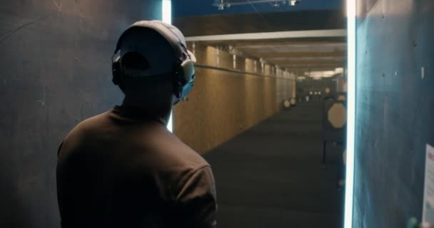 Muž střelec kontroluje cíl ve střelnici — Stock video