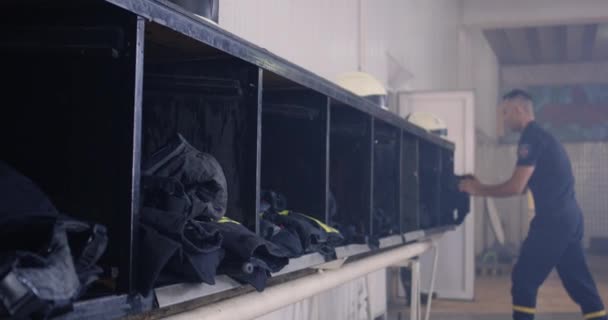 Dappere brandweermannen die zich kleden voor noodoproep — Stockvideo