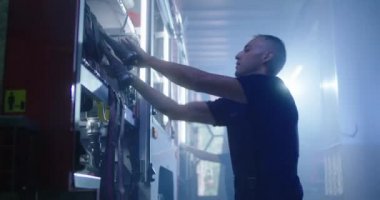 İtfaiyeci itfaiye arabasına hortum takıyor.