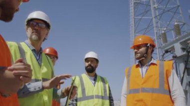 Elektrik santrali inşaatını tartışan inşaatçılar