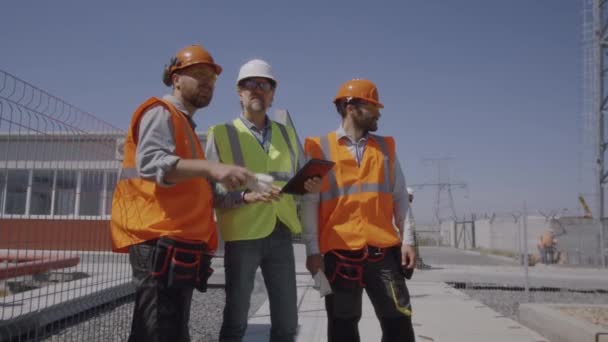 Constructores discutiendo construcción de centrales eléctricas — Vídeo de stock