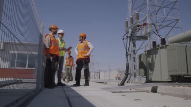 Строители обсуждают строительство электростанций — стоковое видео