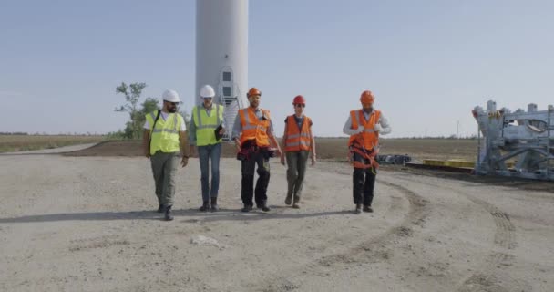 Group of engineers walking and talking on wind farm — Stock Video