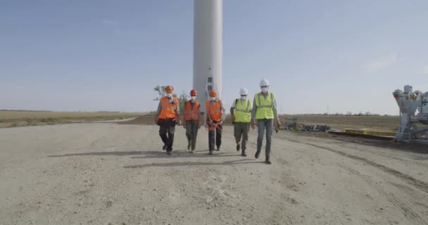 Groep ingenieurs lopen en praten op windmolenpark — Stockvideo
