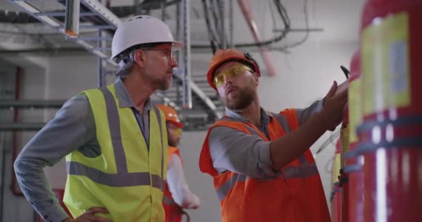Инженеры, изучающие огнетушители на электростанции — стоковое видео