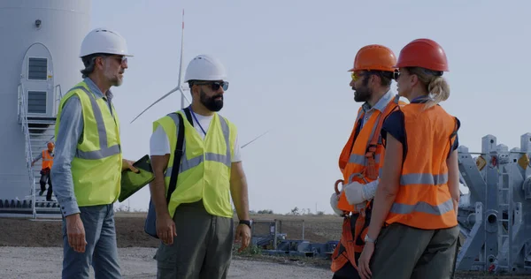Engenheiros que inspecionam o local de construção perto do moinho de vento — Fotografia de Stock