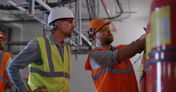 Ingénieurs examinant les extincteurs de la centrale électrique — Photo