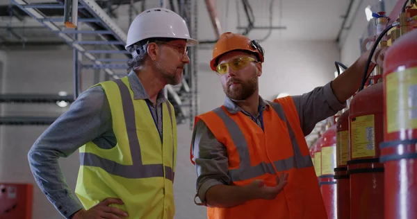 Enerji santralindeki yangın söndürücüleri inceleyen mühendisler