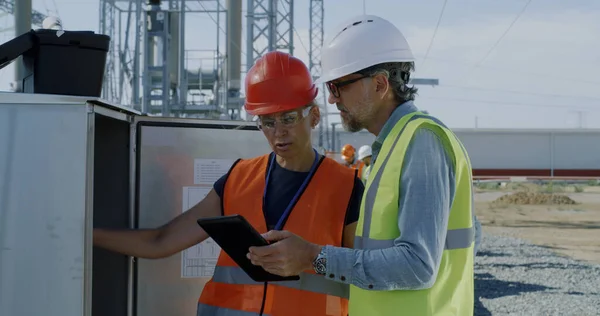 Engineers checking transformer box on power plant