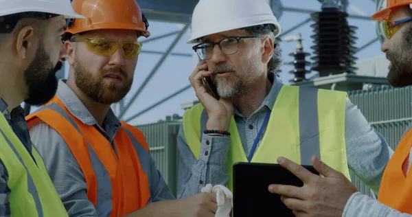 Rijpe ingenieur in gesprek op smartphone tijdens vergadering op elektriciteitscentrale — Stockfoto
