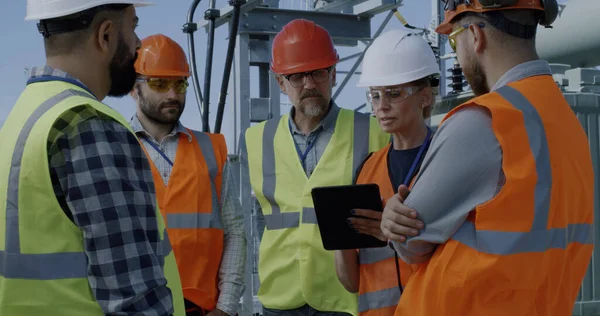 Foreman explaining data to employees on power plant