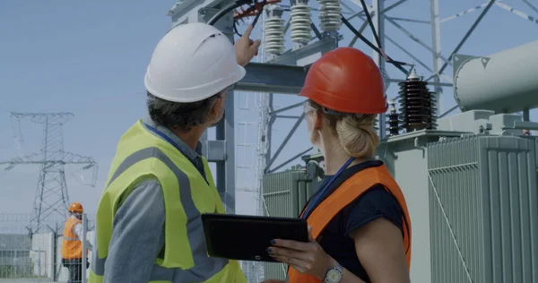 Ingenieros maduros examinando datos y equipos de centrales eléctricas — Foto de Stock