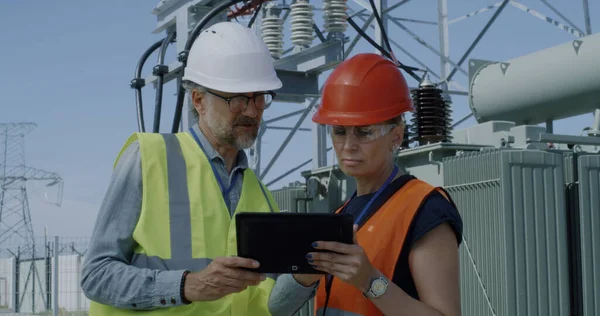 Ingenieros maduros examinando datos y equipos de centrales eléctricas — Foto de Stock