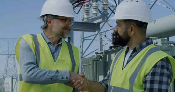 Rijpe ingenieur toont gegevens aan bebaarde collega — Stockfoto