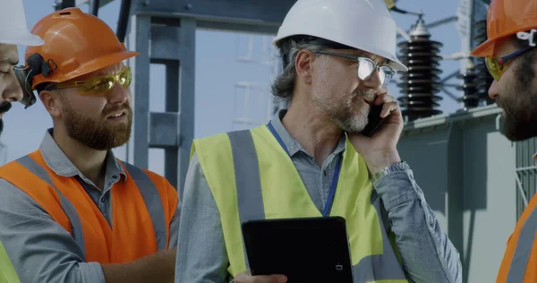 Rijpe ingenieur in gesprek op smartphone tijdens vergadering op elektriciteitscentrale — Stockfoto