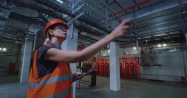 Kadın müfettiş erkek işçiye sorular soruyor.