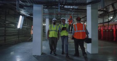 Mühendisler elektrik santralinin karanlık atölyesini inceliyorlar.