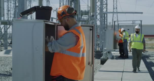 Engenheiros fixando transformador durante a inspeção — Vídeo de Stock