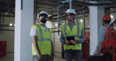 Gözlüklü erkek müteahhitler tavanı inceliyor