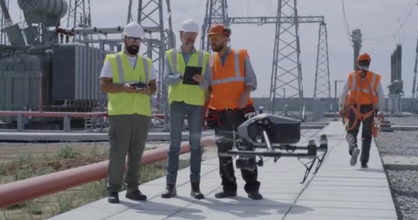 Dipendenti che utilizzano tablet e controllano il drone sulla centrale elettrica — Video Stock