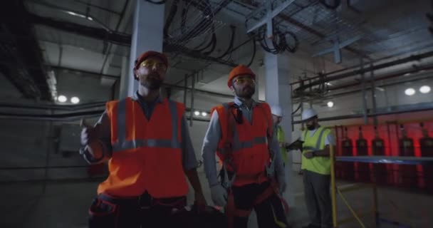 Чоловіки робітники ходять і розмовляють на заводі — стокове відео